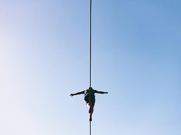 person walking on tightrope against blue sky